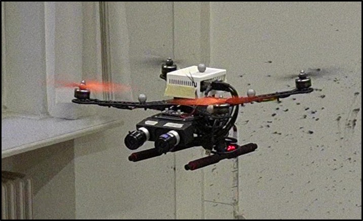 A quadrotor carrying a stereo event-camera payload in flight indoors